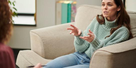 Frau auf Sofe unterhält sich mit anderer Frau