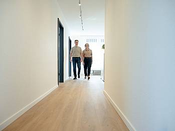 2 Personen laufen durch hellen Flur